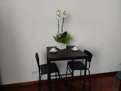 a black table with chairs and a vase with flowers at Pepe's Place - Re di Roma in Rome