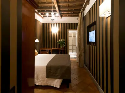 a bedroom with a bed and a table and a television at IG Suites in Rome