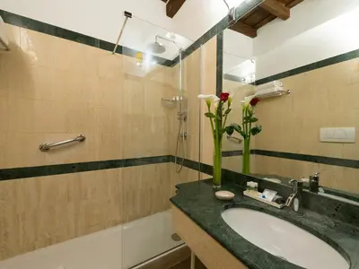 a bathroom with a sink and a vase of flowers at IG Suites in Rome