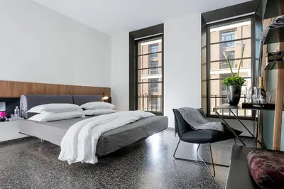 a bedroom with a large bed and a chair at Hotel Royal Bissolati in Rome