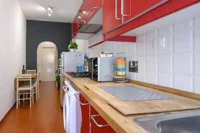 a kitchen with red and white tiles and a counter at Monserrato Apartment in Rome