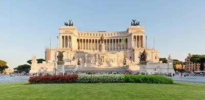 a large building with a grassy field in front of it at Monserrato Apartment in Rome
