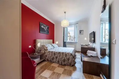 a bedroom with a bed and a red wall at La Dolce Vita Barberini in Rome