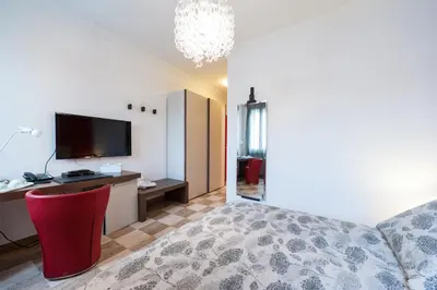 a bedroom with a bed and a desk and a television at La Dolce Vita Barberini in Rome