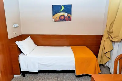 a bedroom with a bed and a painting on the wall at Hotel Cervia in Rome