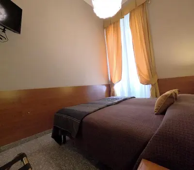 a bedroom with a bed and a window at Hotel Cervia in Rome