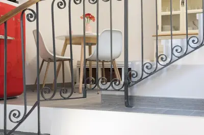 two chairs and a table behind a fence at Quiet pied a terre with terrace in Borgo Pio in Rome