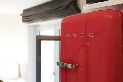 a red refrigerator with the word synergy written on it at Quiet pied a terre with terrace in Borgo Pio in Rome