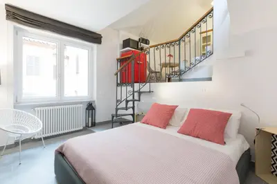a bedroom with a bed and a spiral staircase at Quiet pied a terre with terrace in Borgo Pio in Rome
