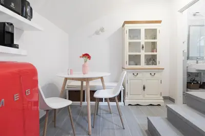 a dining room with a table and chairs and a cabinet at Quiet pied a terre with terrace in Borgo Pio in Rome