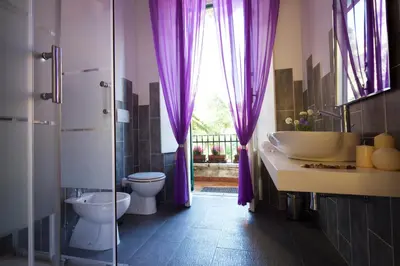 a bathroom with purple curtains and a sink and a toilet at Il Tempio di Morfeo in Rome
