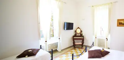 a bedroom with two beds and a chair and a tv at Il Tempio di Morfeo in Rome