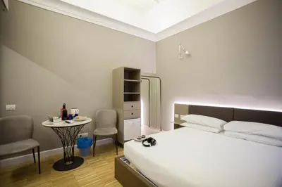 a bedroom with a bed and a table and chairs at Ripetta 25 Prestige Rooms in Rome