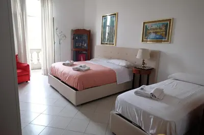 a bedroom with two beds and a red chair at Interno 7 in Rome