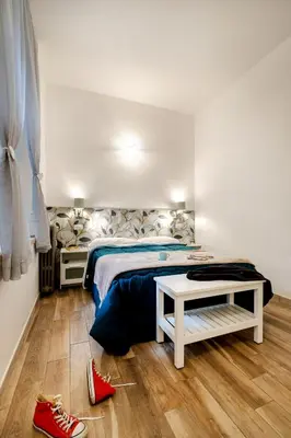 a bedroom with a bed and red shoes on the floor at Vatican36 Guest House in Rome