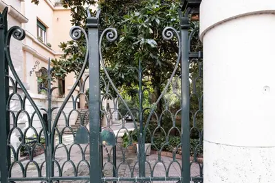 a black iron gate with a tree behind it at Vatican36 Guest House in Rome