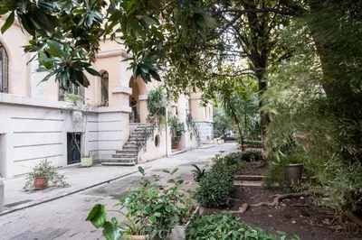 an empty street in front of a building with trees at Vatican36 Guest House in Rome