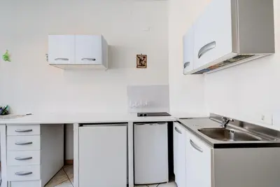 a white kitchen with a sink and white cabinets at In the Center by Local Domus in Rome