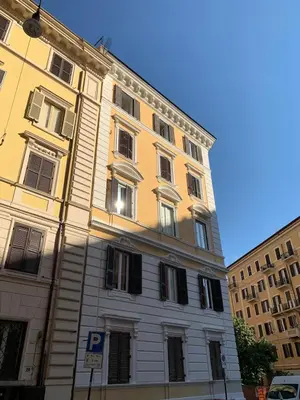 a tall yellow building with a parking sign in front of it at In the Center by Local Domus in Rome