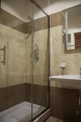 a shower with a glass door next to a sink at Federica's Home in Rome