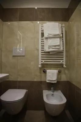 a bathroom with a toilet and a sink and towels at Federica's Home in Rome