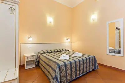 a hotel room with two beds and a mirror at Vatican Town in Rome