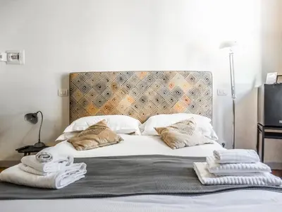 a bed with towels sitting on top of it at Mecenate Rooms in Rome