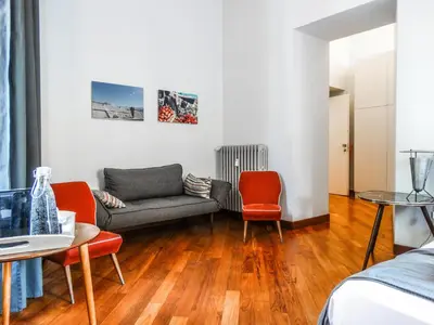 a living room with a couch and two chairs at Mecenate Rooms in Rome