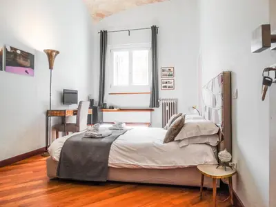 a bedroom with a bed and a table and a window at Mecenate Rooms in Rome