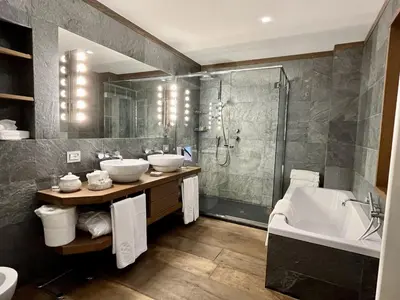 a bathroom with two sinks and a shower and a tub at Villa Spalletti Trivelli - Small Luxury Hotels of the World in Rome