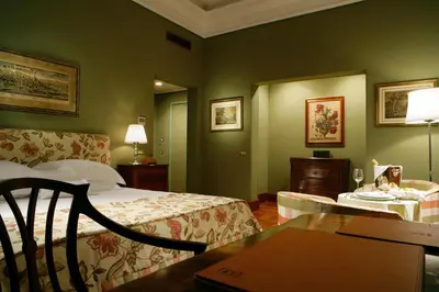 a hotel room with a bed and a desk with a table at Villa Spalletti Trivelli - Small Luxury Hotels of the World in Rome
