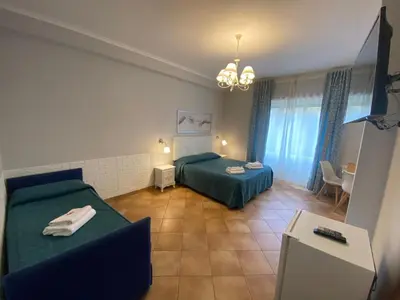 a bedroom with two beds and a table and a room at Domus Prati in Rome
