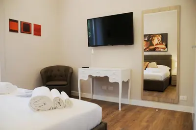 a room with two beds and a television on a wall at Nomentana House in Rome
