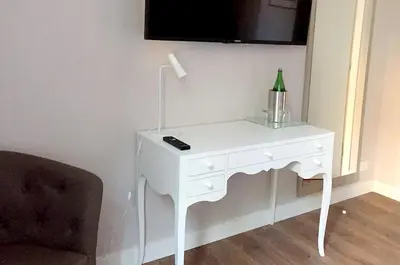 a white table with a bottle on it next to a chair at Nomentana House in Rome
