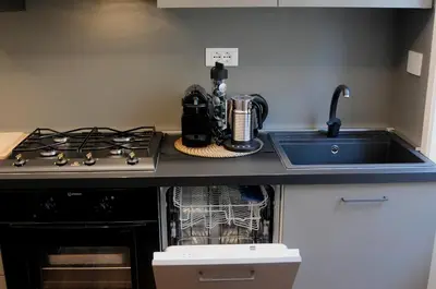 a kitchen counter with a stove and a sink at Nomentana House in Rome