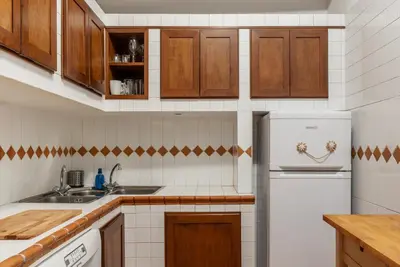 a kitchen with wooden cabinets and a white refrigerator at GuestHost - Pantheon Charming Apartment in Rome