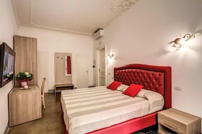 a bedroom with a large bed with a red headboard at Feronia Guest house in Rome
