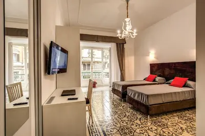 a hotel room with two beds and a flat screen tv at Feronia Guest house in Rome
