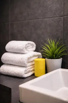 a pile of towels on a counter next to a sink at Tolli Colosseo Apartment in Rome