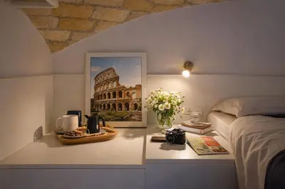 a kitchen with white cabinets and a staircase at Tolli Colosseo Apartment in Rome