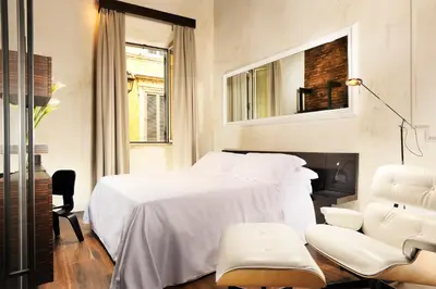 a bedroom with a white bed and a fireplace at Relais Orso in Rome