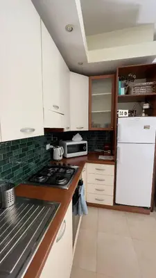 a kitchen with white cabinets and a white refrigerator at Asher's House Colosseum in Rome