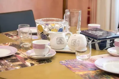 a table with plates and cups and glasses on it at Stradivari Luxury Apartment in Rome