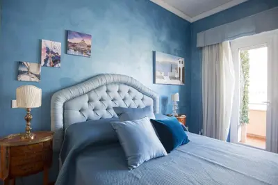 a blue bedroom with a king sized bed with blue walls at Stradivari Luxury Apartment in Rome