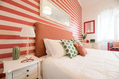 a bedroom with a red and white striped wall at Suite 06 in Rome
