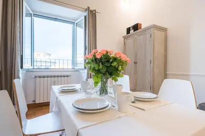 a white table with a vase of flowers on it at Suite 06 in Rome