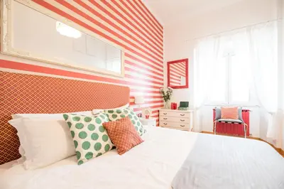a bedroom with a bed with red and white stripes at Suite 06 in Rome