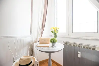 a table with a book and flowers on a window at Suite 06 in Rome