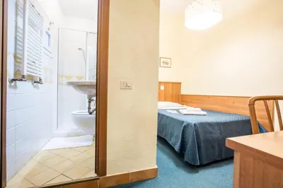 a bathroom with a bed and a toilet and a sink at Hotel Trastevere in Rome