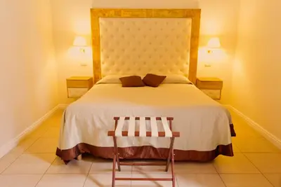 a bedroom with a large bed and two chairs at Caput Mundi Suite in Rome